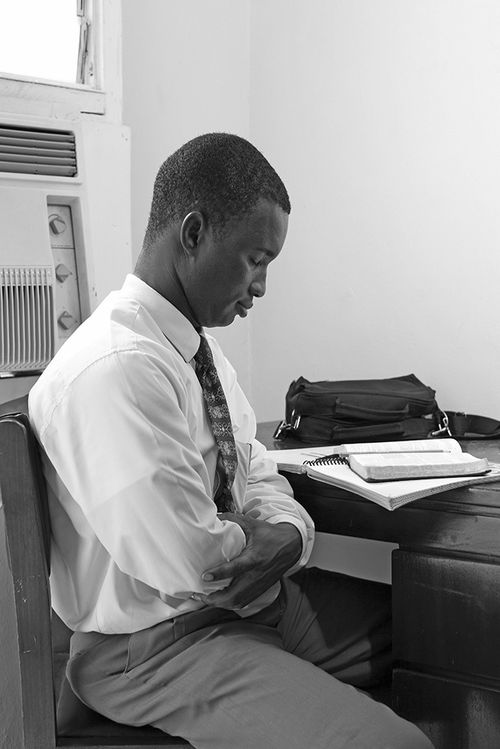 Young man praying before scripture study