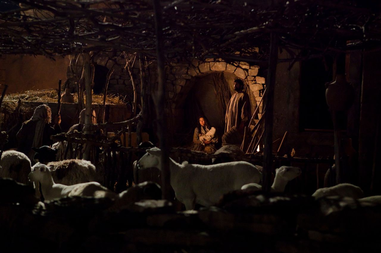 Shepherds surround the stable in which Jesus was born and greet Him