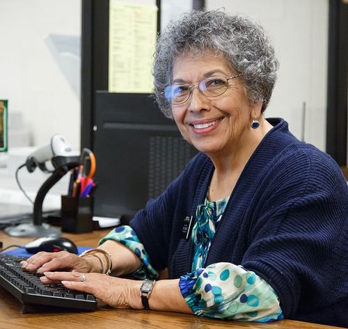 elderly woman smiling with computer