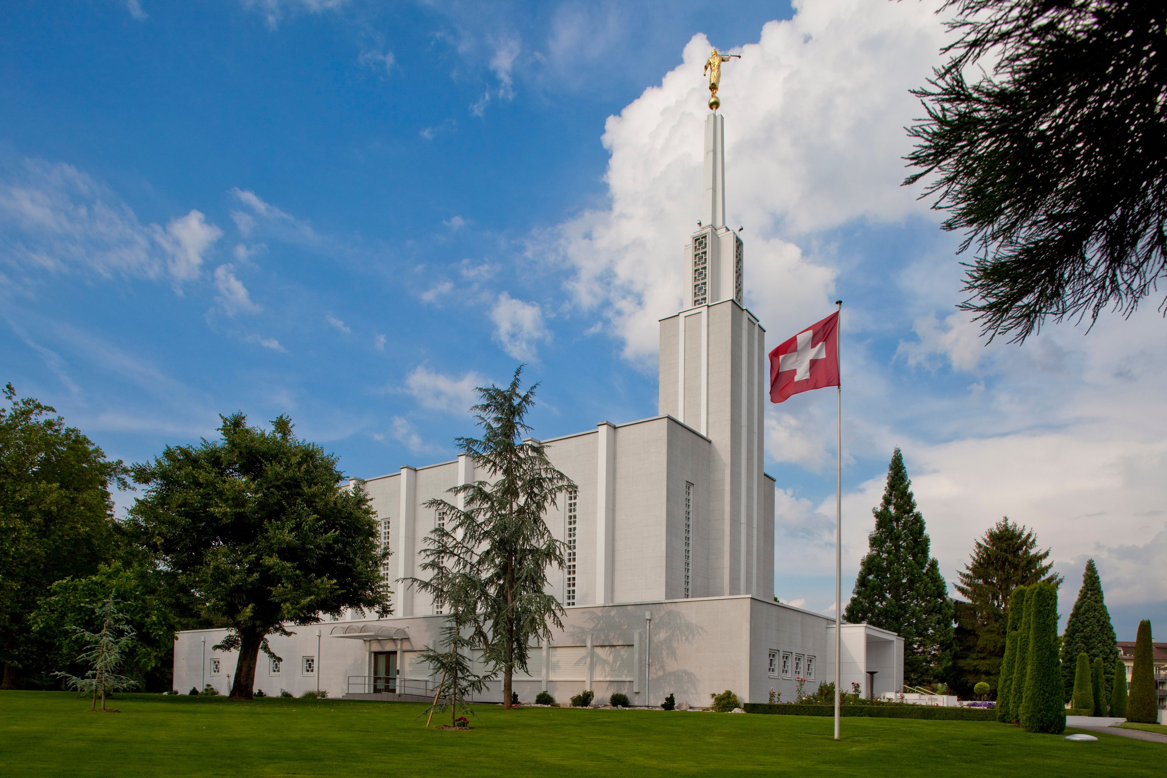 A side view of the Bern Switzerland Temple and Swiss flag on the grounds.  