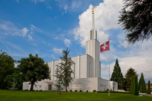 The side of the Bern Switzerland Temple, with the Swiss flag flying in the foreground.