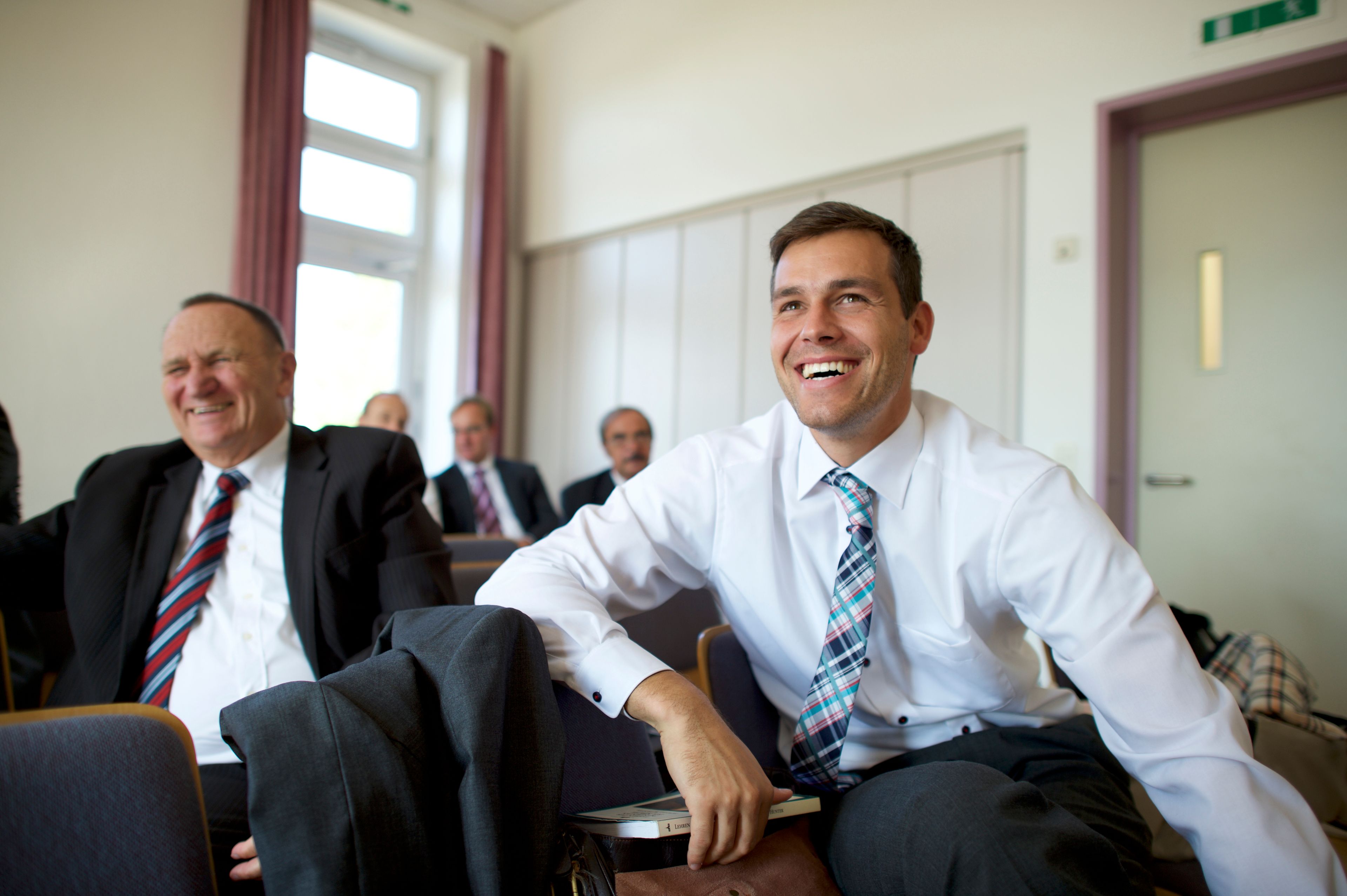 Men in Germany sit and participate in elders quorum.