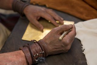 Moroni writing on gold plates