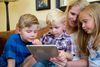 mãe e filhos usando um tablet
