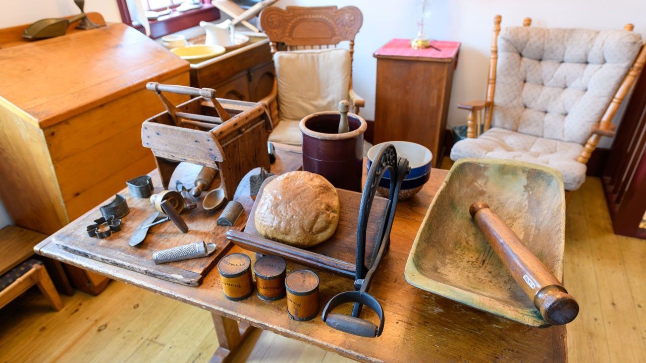 The interior of a bakery. A table sits in the middle of the room, various tools used for baking are on display.