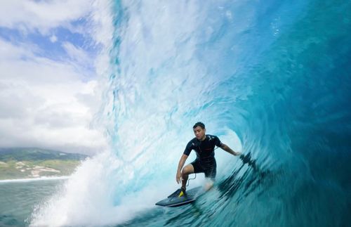 a man surfing in the barrel of a wave