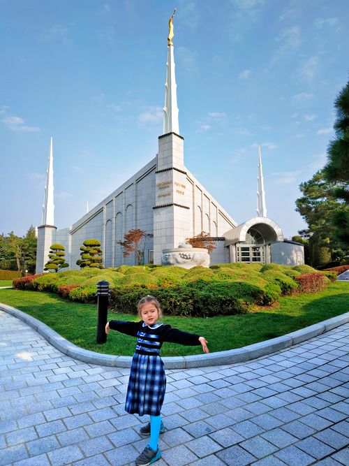 A little Russian girl standing in front of a Temple.