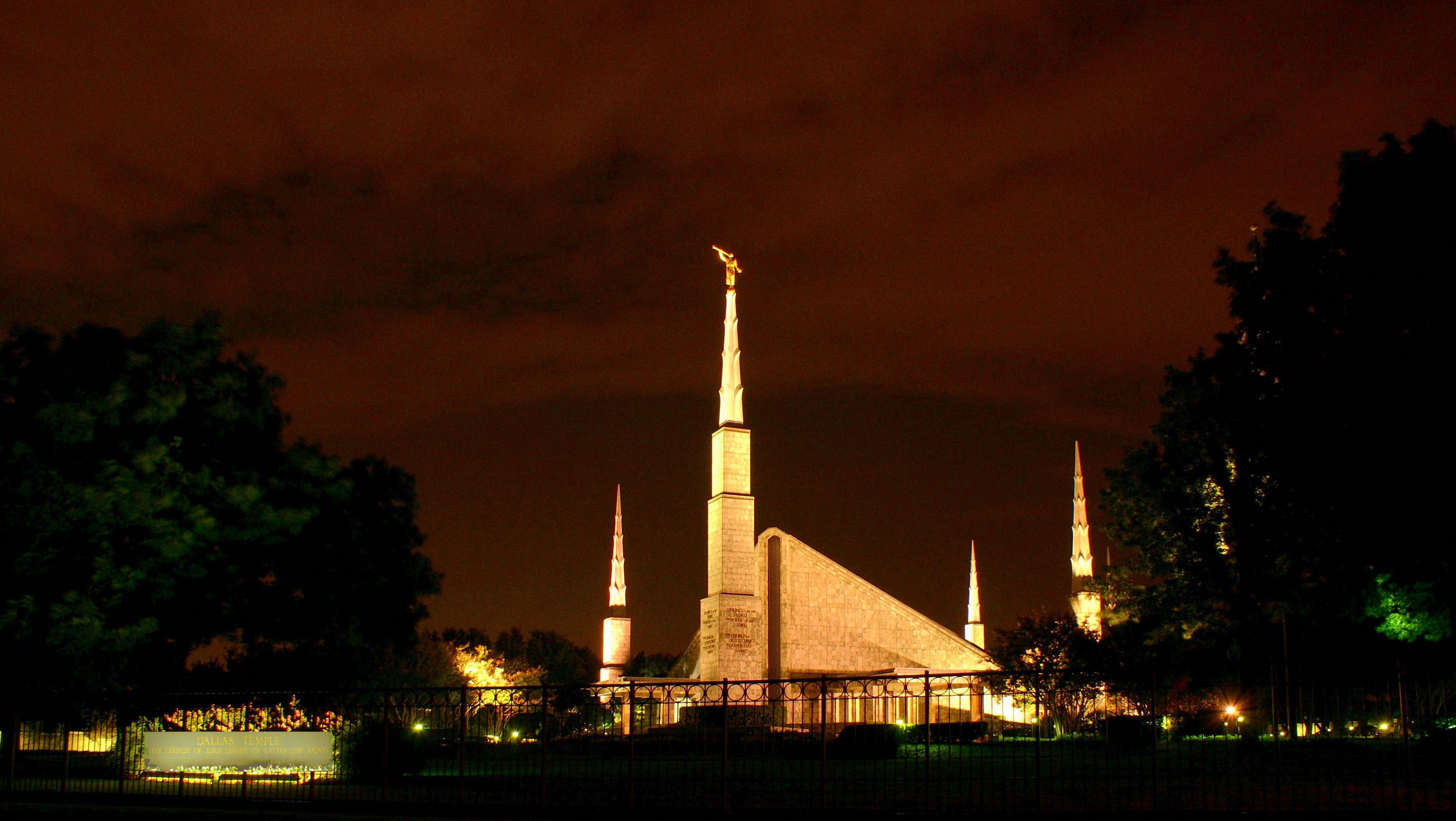 The Dallas Texas Temple is lit up at night.