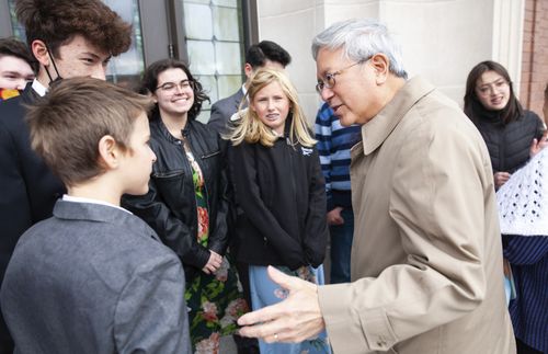 Elder Gong speaking with youth in front of temple