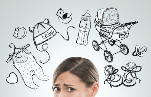 woman pondering with drawings related to babies