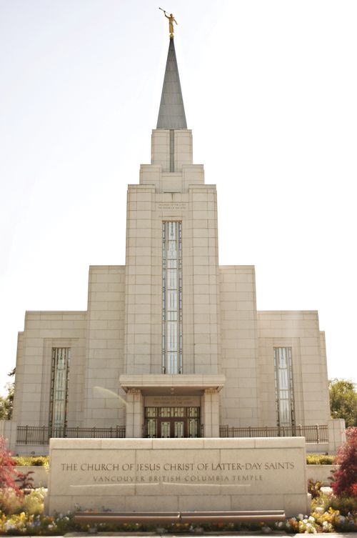 The front entrance to the Vancouver British Columbia Temple, with the name sign and a view of the angel Moroni on top of the spire.