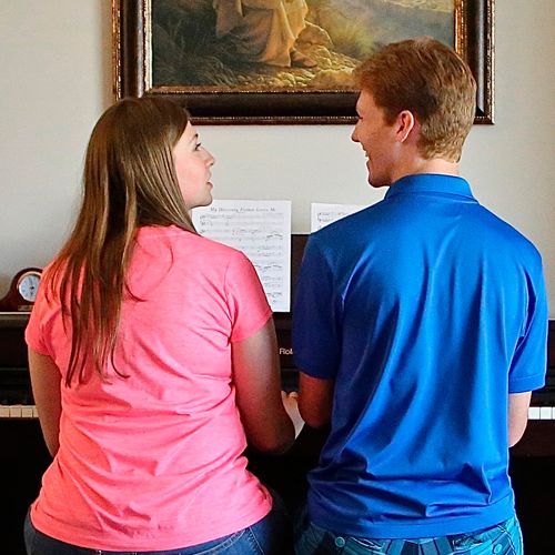 brother and sister playing piano