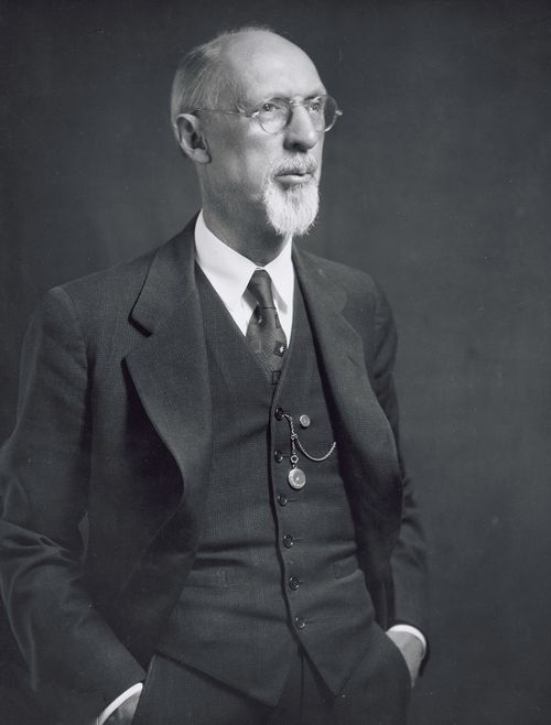 The prophet George Albert Smith in a black suit, with his hands in his pockets and a small pocket watch hanging from his vest.