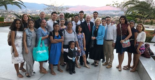 Elder Quentin L. Cook with members on temple grounds in Honduras