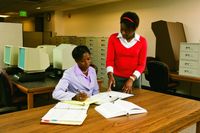 dos mujeres en la mesa de una biblioteca