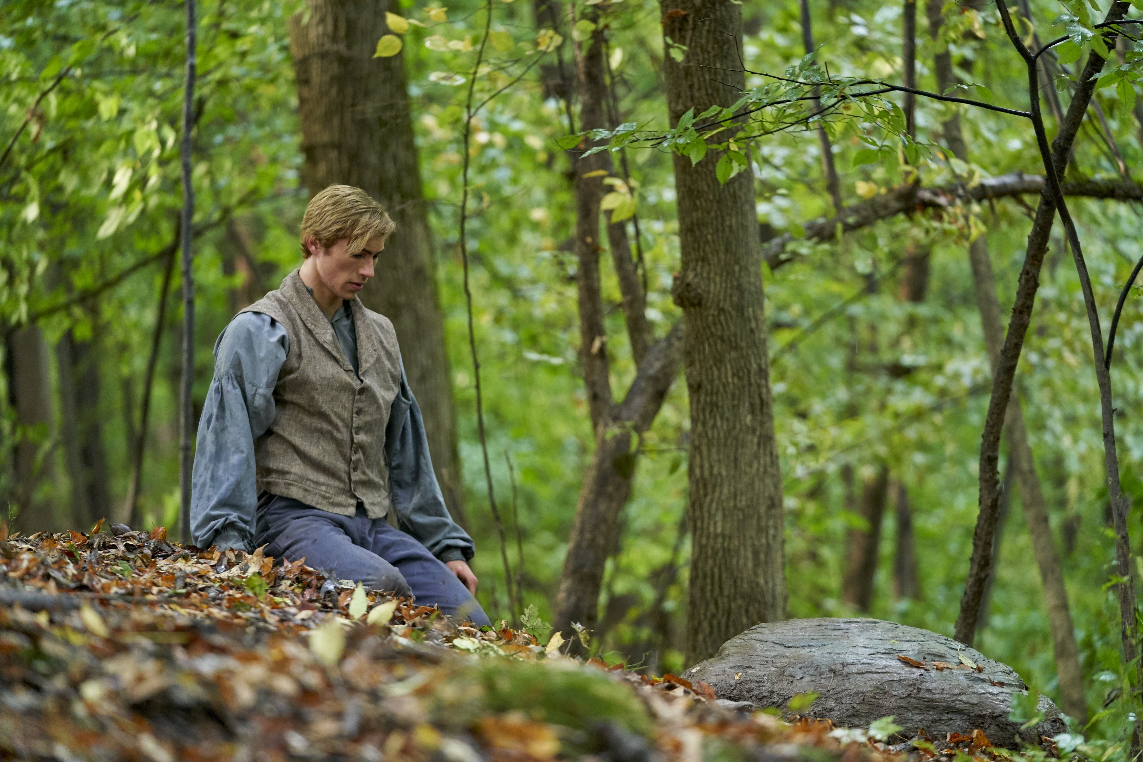 Joseph Smith Jr. kneels in front of the hiding place of the plates on the Hill Cumorah.