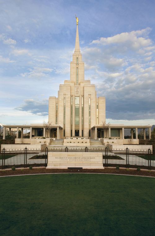 A front view of the Oquirrh Mountain Utah Temple, with the temple’s granite sign and black fence along the front.