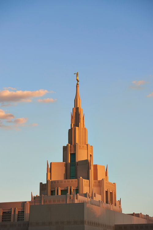 The Phoenix Arizona Temple during sunset with a few clouds in the sky.