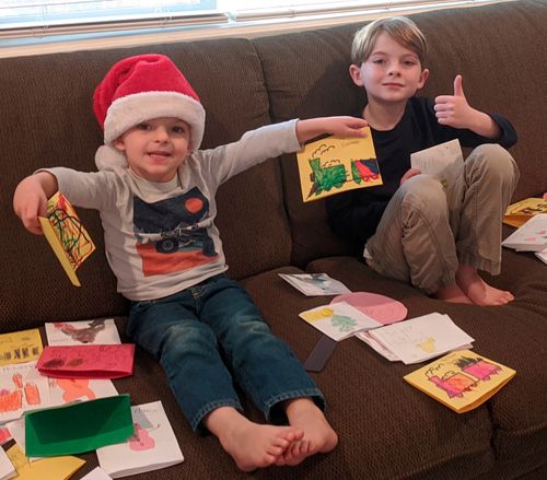 two kids holding up homemade Christmas cards