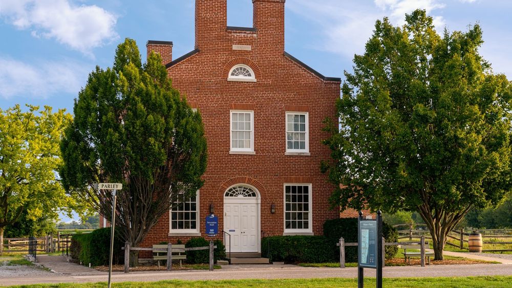 A two-and-a-half-story brick structure with a white double door entrance.