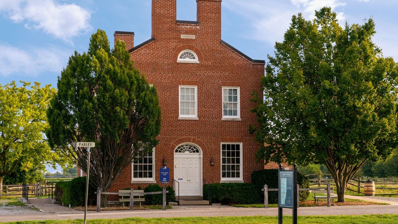 A two-and-a-half-story brick structure with a white double door entrance.