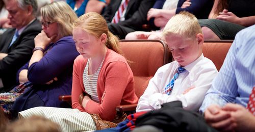 young man and young woman praying at conference