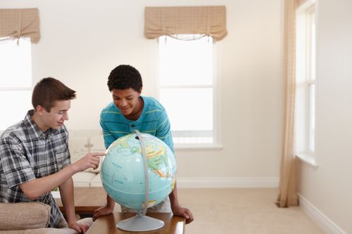young men looking at globe