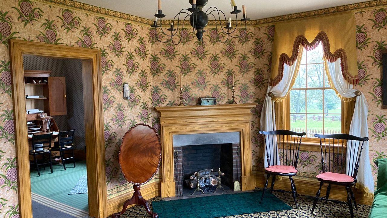 Carpeted and wallpapered room with a fireplace and well-appointed furnishings.