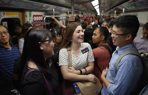 two sister missionaries talking to a man on a train
