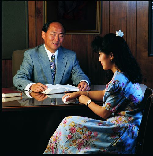 young woman and bishop at his desk