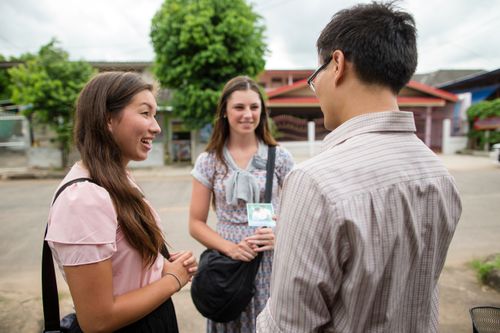 sister missionaries talking with a young man