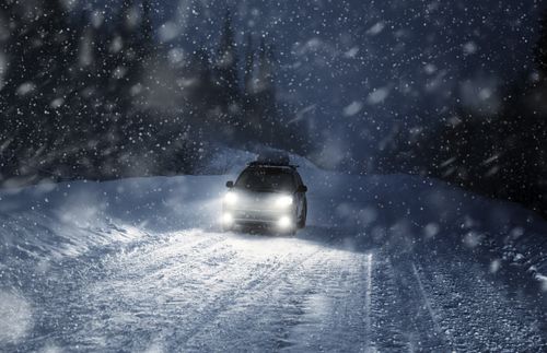 car traveling through snow at night