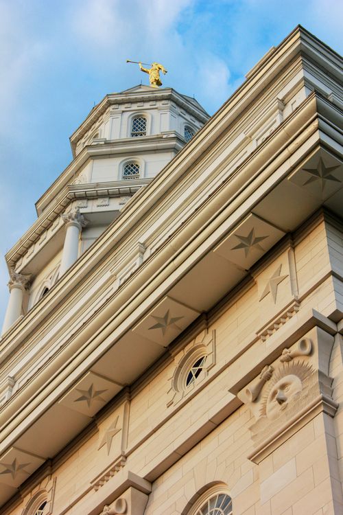 A detail of the sunstones and stars on the outside of the Nauvoo Illinois Temple, with the spire seen beyond them.