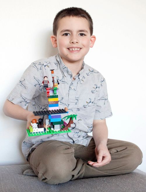 Boy holding plastic brick creation 