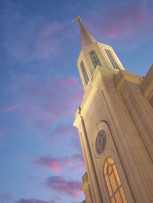 A view up the spire of the St. Louis Missouri Temple in the evening, with a partial view of the windows lit up from inside.