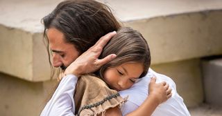 o Salvador abraçando uma criança