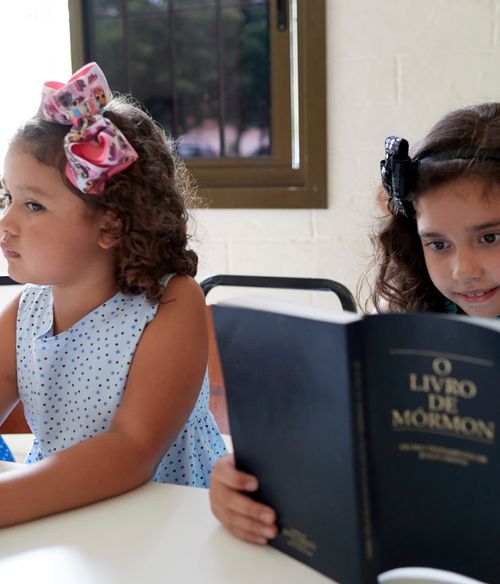 girl reading Portuguese Book of Mormon