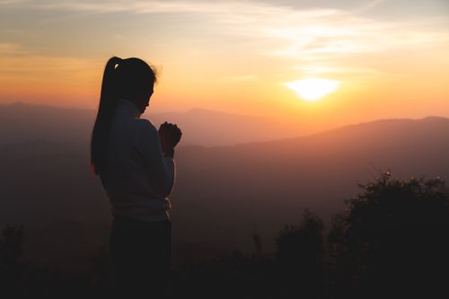 young woman looking at sunrise