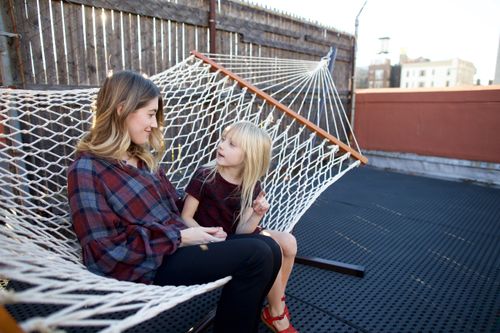 mother and daughter sitting in hammock