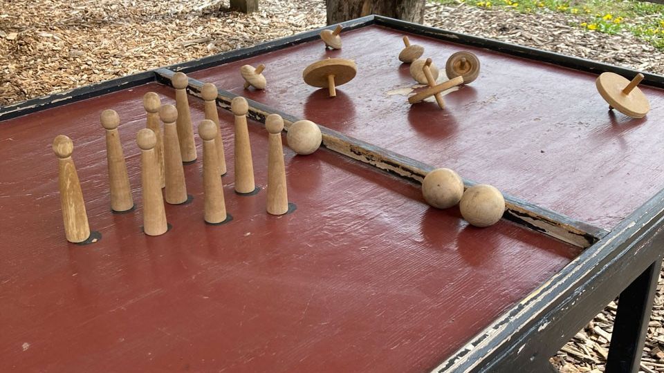 Close-up of a table with a bowling pin game and wooden tops.