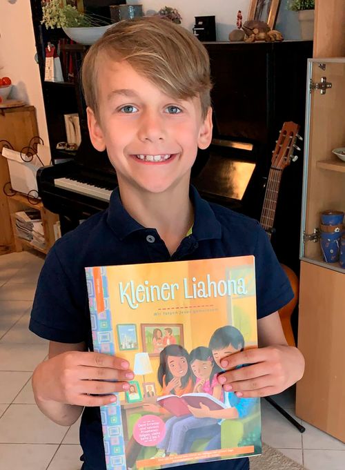 Smiling boy holding the Friend magazine