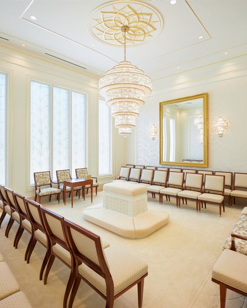 A Port-au-Prince Haiti Temple sealing room with an altar surrounded by chairs and a chandelier.