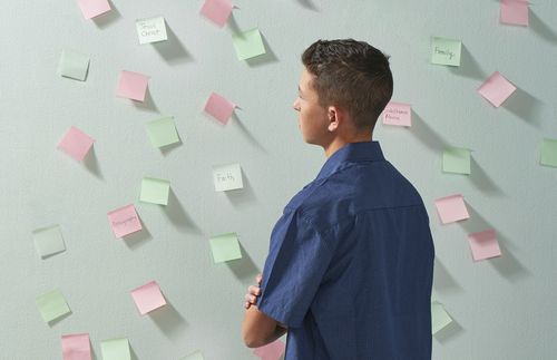 young man looking at notes on wall