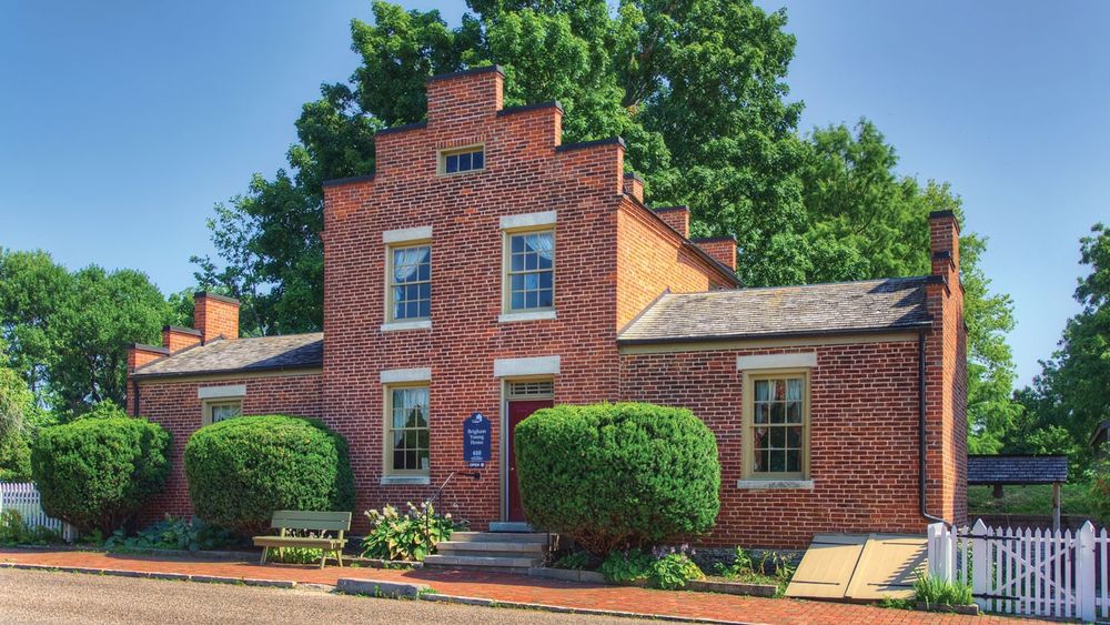 A two-story red brick home with single-story additions on either side.