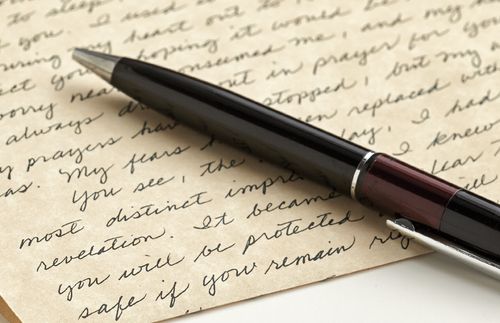 A pen lying on a handwritten letter.