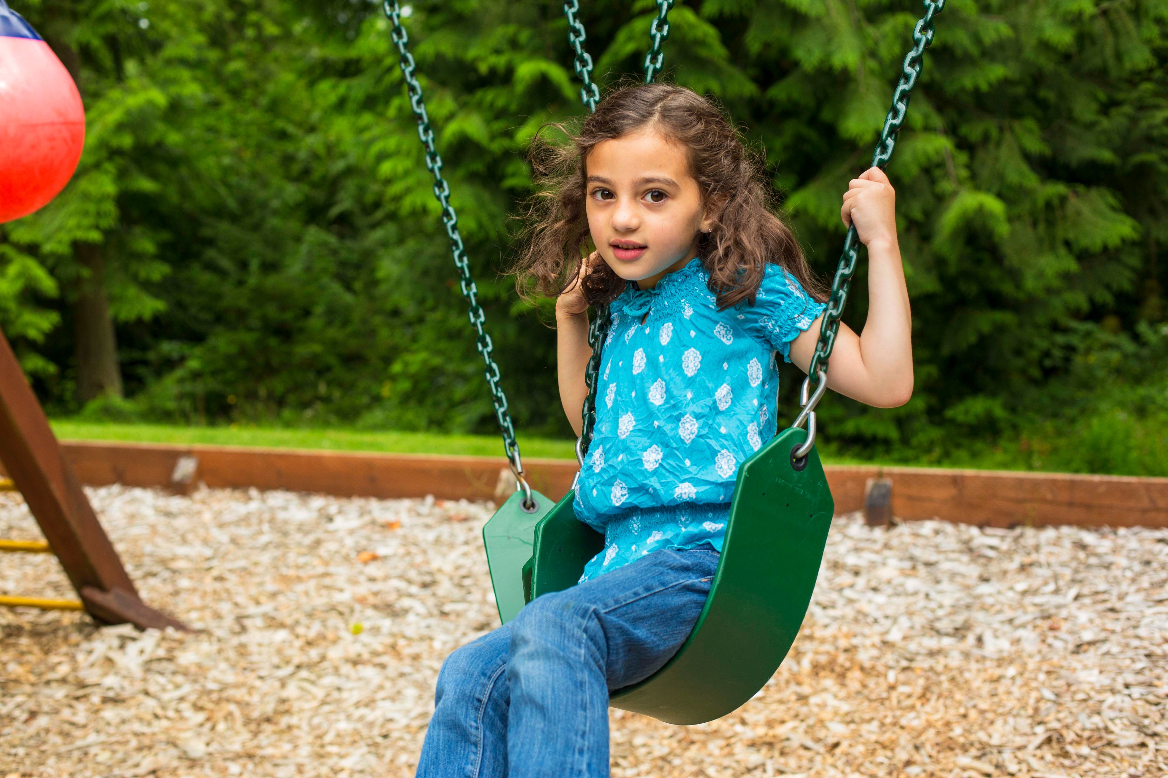 A young girl swinging.  