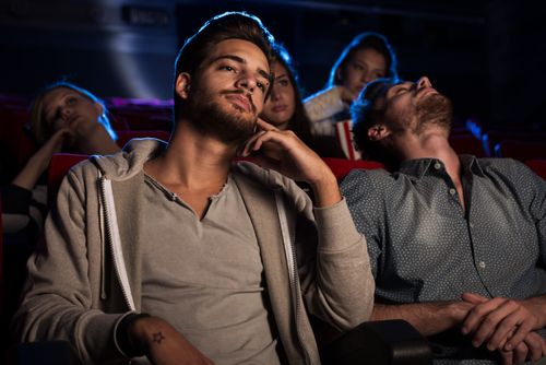 Two men watching a movie in theater