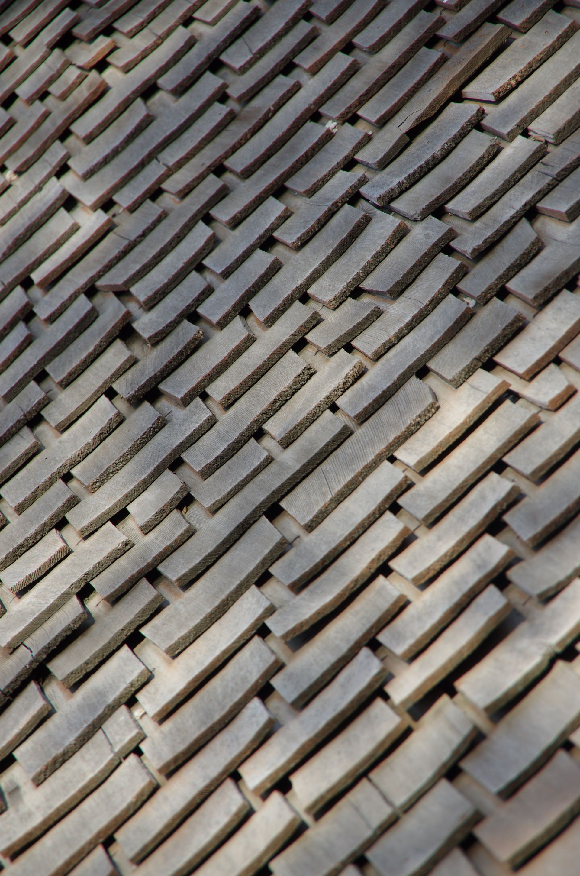 A pattern of gray wooden shingles neatly put together.