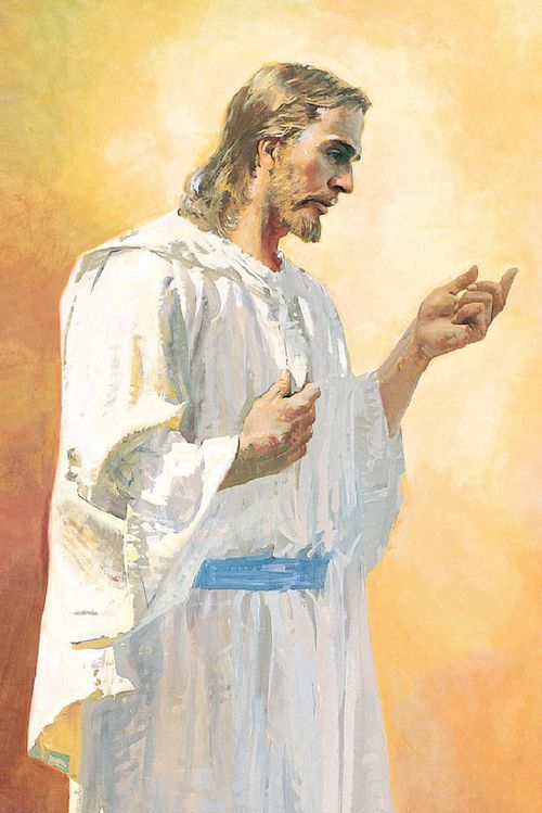 Full length profile portrait of Jesus Christ. He is depicted wearing a white robe with a blue belt. He has one hand extended. His other hand is touching His chest.