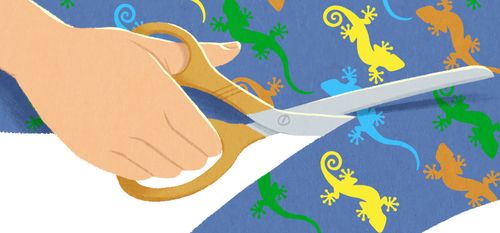 boy cutting fabric with geckos on it